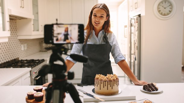 Eine Frau filmt sich beim Backen. 