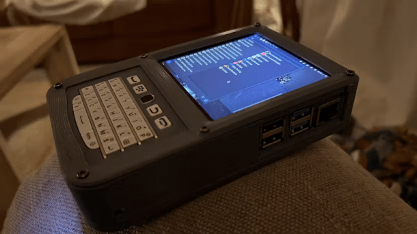 Ein 3D-gedrucktes Gerät in der Form eines Blackberrys liegt mit eingeschaltetem Display