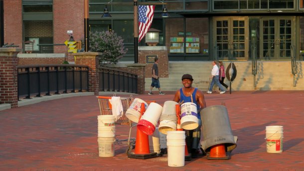 Musikant mit Schlagzeug aus Plastikkübeln
