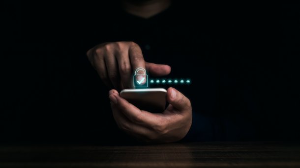 Hand am Smartphone zeigt auf grünen Haken