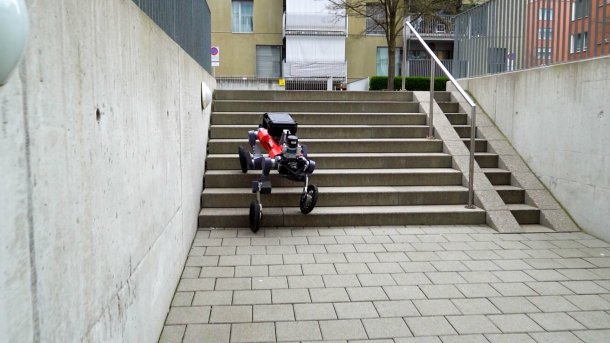 Roboter mit Rädern geht Treppe herunter.