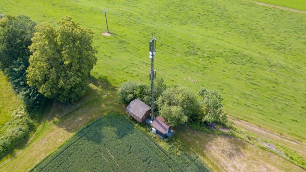 Ein Mobilfunkmast auf dem flachen, grünen Land