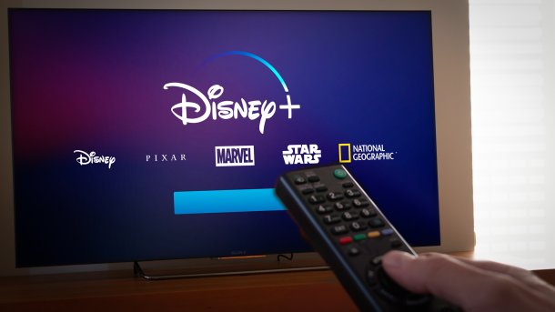 Disney+ logo on the TV to which a remote control is directed