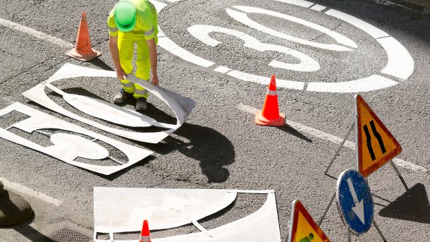 Arbeiter sprühen 30er und 50er Begrenzungen auf Straße