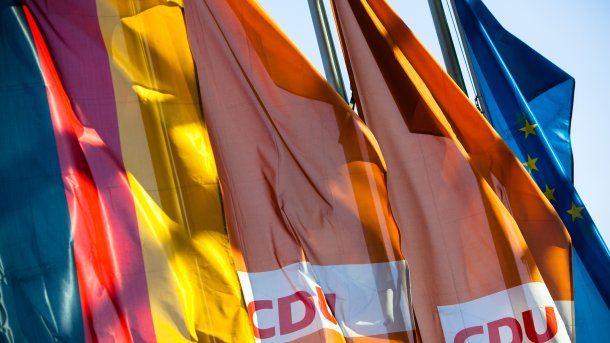 CDU-Schriftzug auf Flaggen, daneben Deutschlandfahnen
