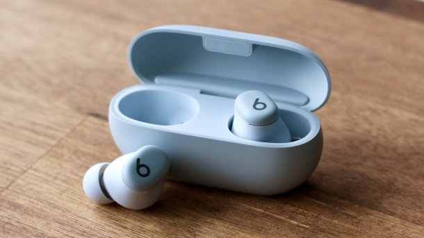 Beats Solo Buds in ihrem Kästchen auf einem Holztisch