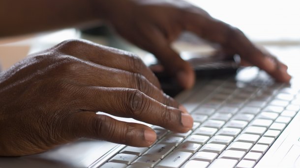 Schwarze Hände auf Tastatur