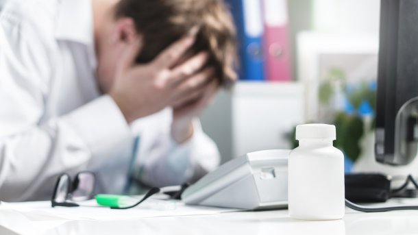 Unhappy doctor in front of a card reader and a computer