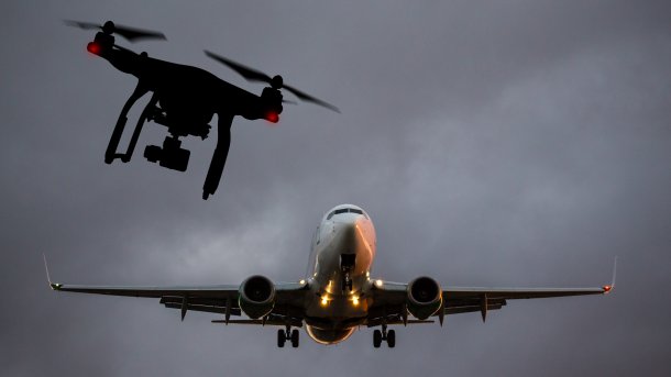 Drohne neben Flugzeug