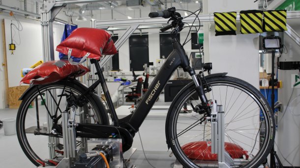 E-bike tested by the ADAC with weight bags on the saddle and luggage rack at a test station
