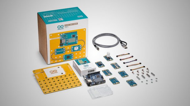Ein Arduino UNO und sieben kleinere Bauteile liegen vor einer Schachtel