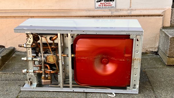 Eine alte Gastherme liegt auf einer Straße.