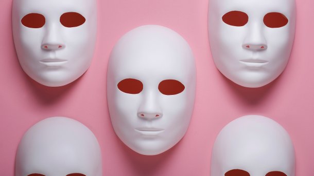 Gipsmasken auf rosa Hintergrund