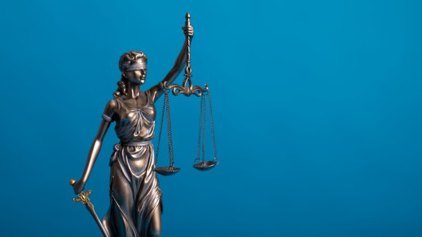 Bronze Justitia against a blue background