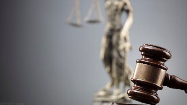 Gerichtshammer vor Justitia-Büste