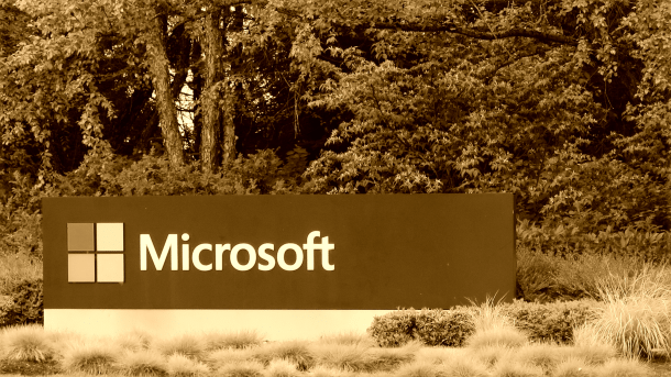 Schild "Microsoft" an Einfahrt zu Firmencampus, dahinter Bäume
