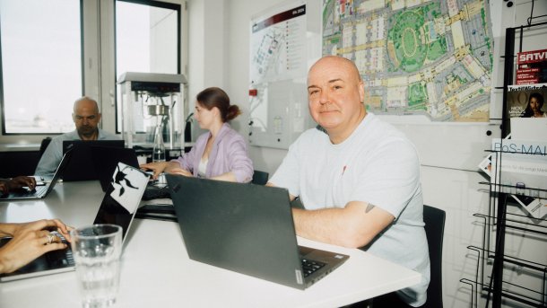 IFA-Chef Leif Lindner und einige Kollegen sitzen mit Laptops um einen Bürotisch.