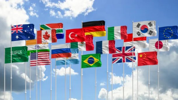 The flags of the G20 countries are hoisted on flagpoles.