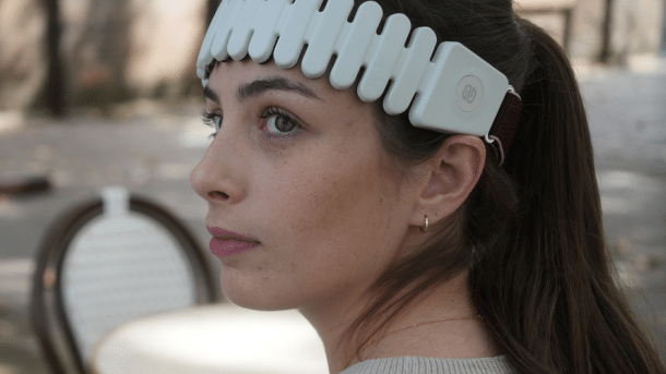 Frau mit Wearable-Stirnband zur ADHS-Behandlung auf dem Kopf
