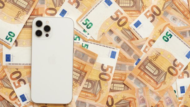 Ein Smartphone liegt auf einem Haufen 50-Euro-Scheine