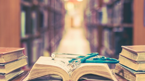 Library with an open book containing a stethoscope.