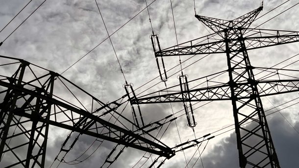 Strommasten vor bewölktem Himmel