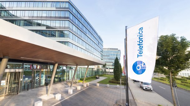 Telefonica Deutschland building in Düsseldorf with company flags at the entrance.