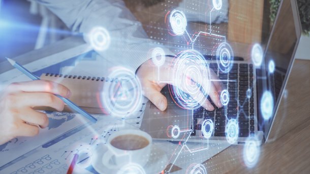 Hand on keyboard, digital symbols in the foreground