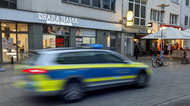 A police car races past
