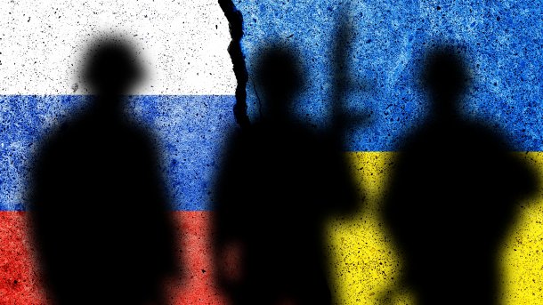Russische und ukrainische Flaggen hinter den Schatten von Soldaten