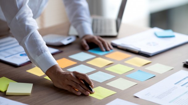 View of a desk with various documents and colorful sticky notes.