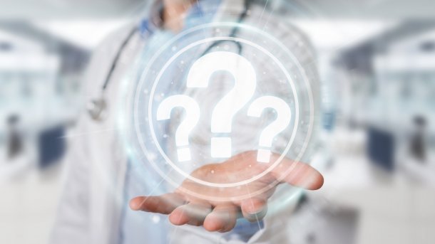 Doctor with a question mark in his hand