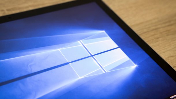 Bildschirm mit Windows-10-Wallpaper auf einem Holztisch liegend