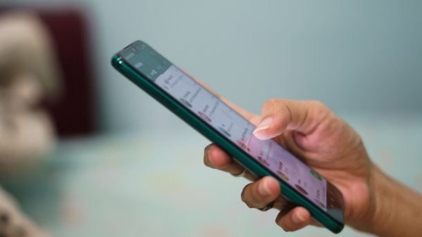 Hand an Smartphone mit WhatsApp offen