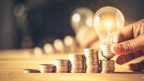 Light bulb stands on coins