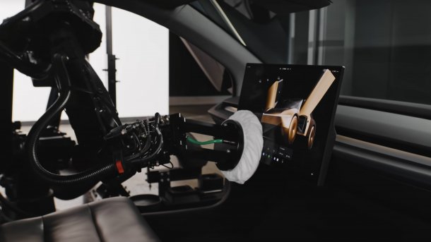Cleaning robot wipes Diaplay clean in a Cybercab.