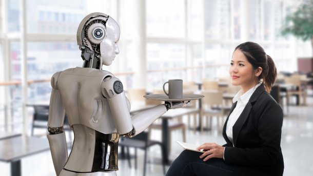 Roboter bringt einer Frau Kaffee.