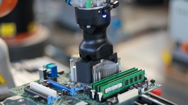 Roboter hebt Motherboard aus Gehäuse.