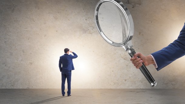 A drawing showing a boss observing his employee with a magnifying glass.