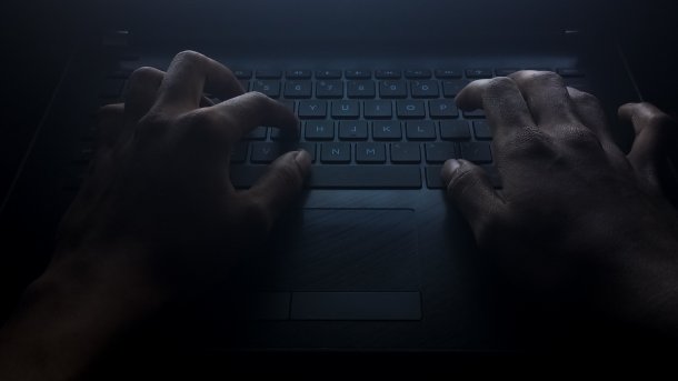 Hands on a keyboard. The picture is in dark colors.