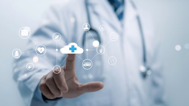 Person im weißen Kittel, mit Stethoskop um den Hals, zeigt auf ein Wolkenzeichen. Drumherum viele Symbole aus dem Medizinbereich.