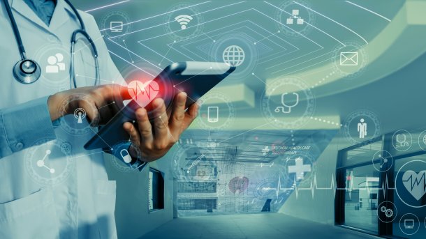 Person, die aussieht wie ein Arzt, drückt mit Finger auf ein Tablet, um ihn herum eine klinische Umgebung