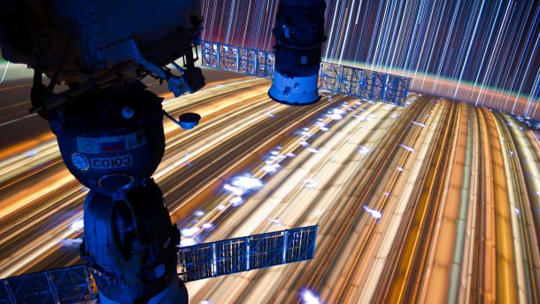 Teile der ISS, darunter die langzeitbelichtete Erde