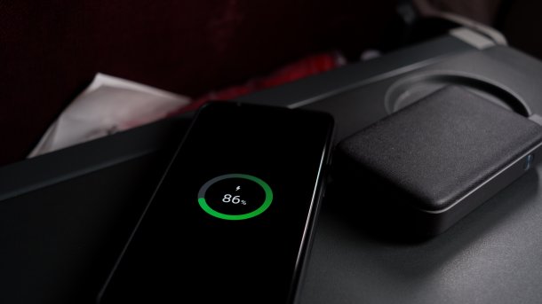 Smartphone, das in Flugzeug per Powerbank geladen wird