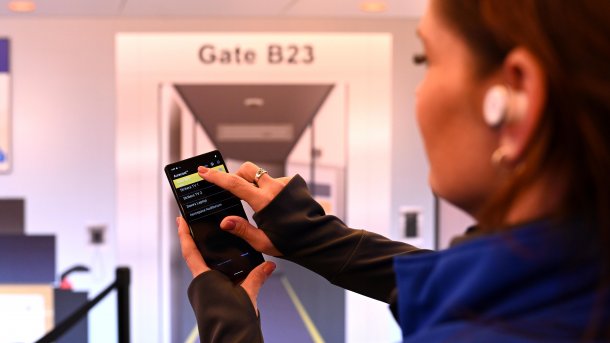 Woman selects Auracast stream on cell phone