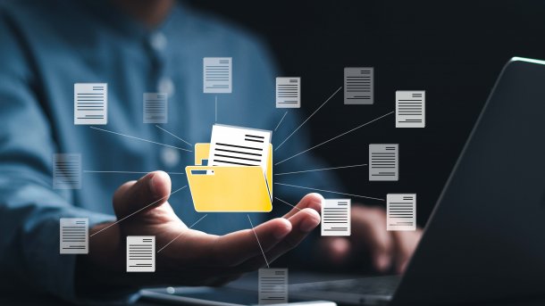 Eine Person sitzt am Laptop. Davor ein Symbol für einen offenen Ordner. Drumherum verschiedene Dateien, ebenfalls als Symbole. 