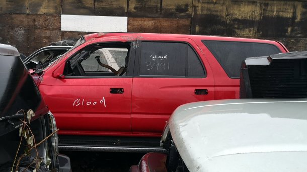 Rotes Autowrack mit Aufschrift "Blood"