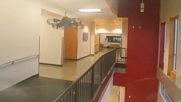 An armed drone flies through a school building.