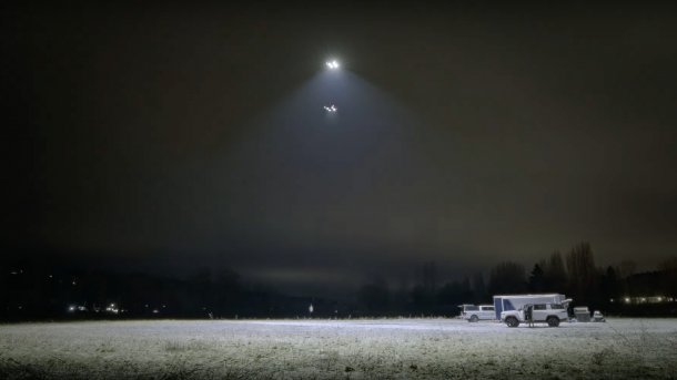 Drone with light illuminates an area.