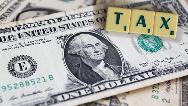 US-Dollar-Note, darauf liegen Scrabble-Buchstaben TAX